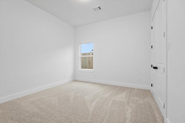 unfurnished room with baseboards, visible vents, and light carpet