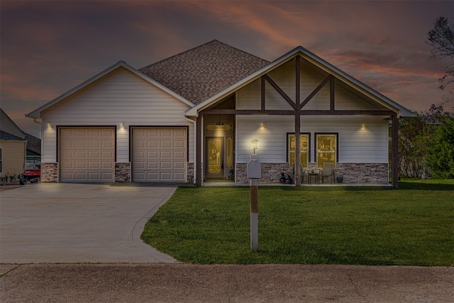 view of front of house with a porch, a yard, and a garage