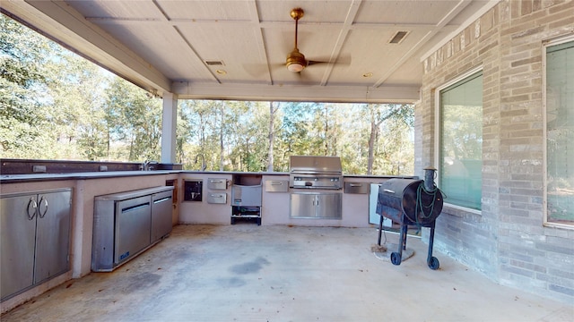 view of patio with grilling area, ceiling fan, and exterior kitchen