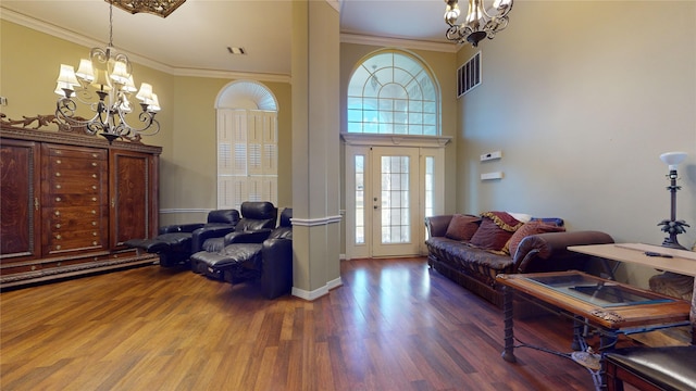 living room featuring dark hardwood / wood-style floors, crown molding, and a notable chandelier