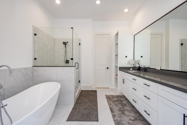 bathroom featuring vanity, shower with separate bathtub, and tile walls