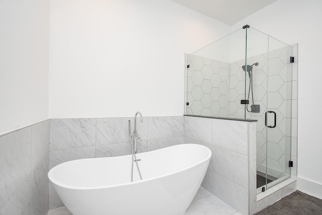 bathroom featuring independent shower and bath and tile walls