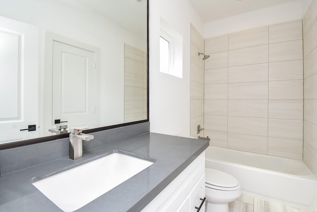 full bathroom with tiled shower / bath combo, vanity, and toilet