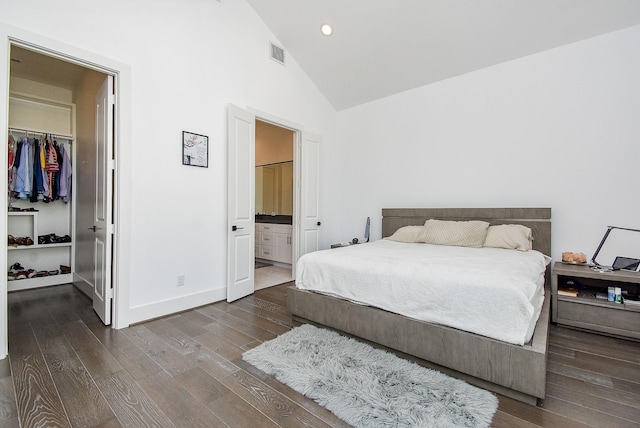 bedroom featuring dark wood-type flooring, ensuite bathroom, a spacious closet, high vaulted ceiling, and a closet