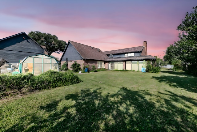 yard at dusk featuring an outbuilding