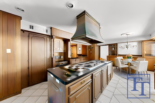 kitchen with custom exhaust hood, light tile patterned floors, decorative light fixtures, and tasteful backsplash