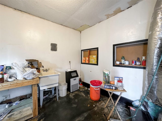 misc room with concrete flooring, a textured ceiling, and sink