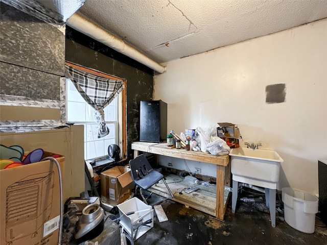 misc room with a workshop area, a textured ceiling, and concrete floors