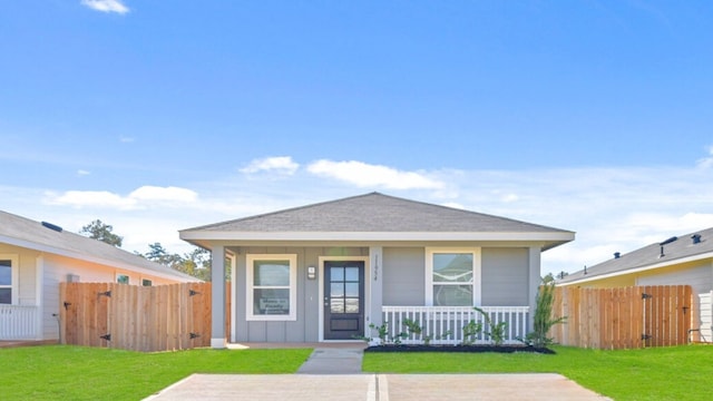 bungalow-style home featuring covered porch and a front yard