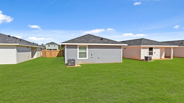 rear view of house with a lawn and cooling unit