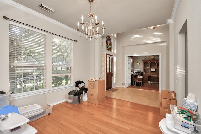 interior space featuring a chandelier, wood-type flooring, and ornamental molding