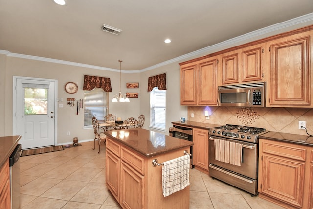 kitchen with pendant lighting, a center island, an inviting chandelier, light tile patterned floors, and appliances with stainless steel finishes