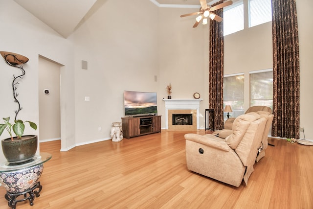 living room featuring ceiling fan, a towering ceiling, and hardwood / wood-style flooring