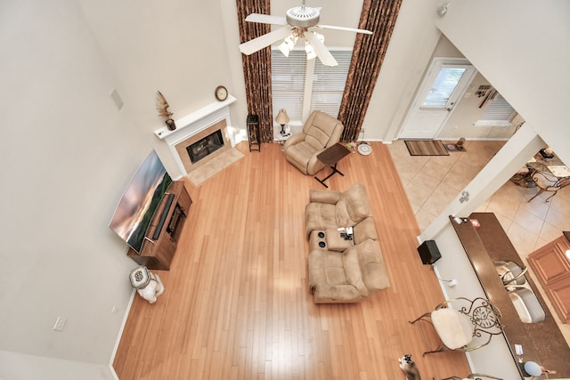 unfurnished living room with a high ceiling, a premium fireplace, and hardwood / wood-style floors