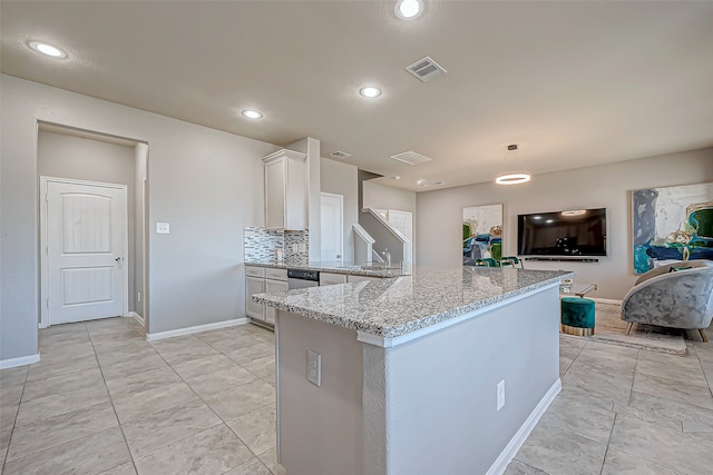 kitchen featuring pendant lighting, dishwasher, light stone countertops, tasteful backsplash, and white cabinetry