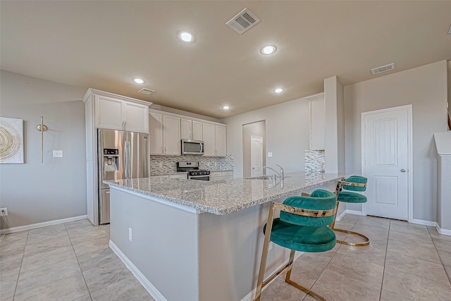 kitchen featuring backsplash, kitchen peninsula, white cabinetry, and appliances with stainless steel finishes