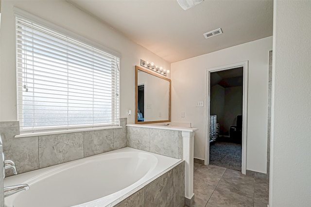 bathroom featuring tile patterned floors, tiled bath, and vanity