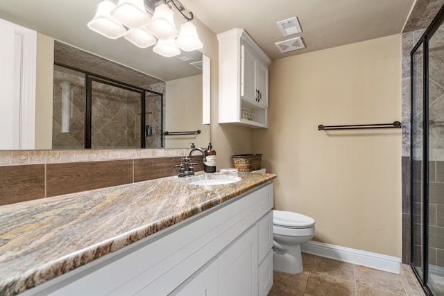 bathroom featuring a shower with door, vanity, and toilet