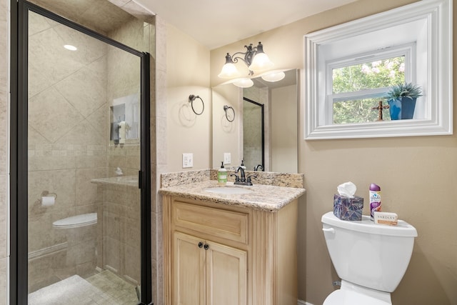 bathroom featuring vanity, a shower with shower door, and toilet