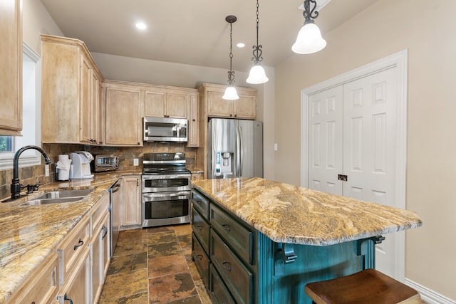 kitchen featuring light brown cabinets, stainless steel appliances, and a kitchen island