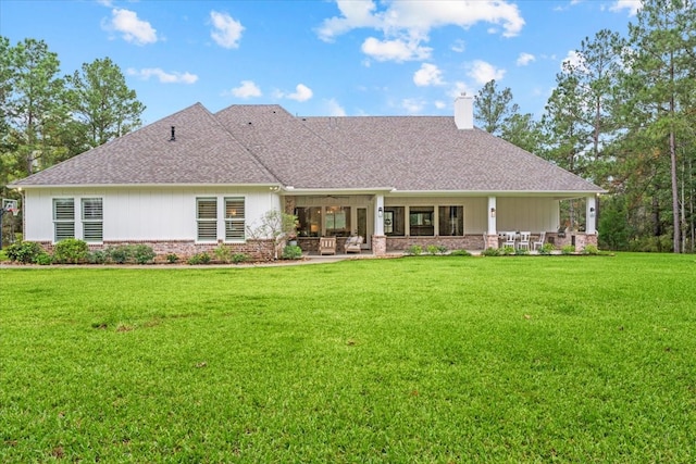 rear view of house featuring a lawn and a patio