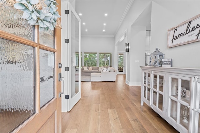 hallway featuring ornamental molding and light hardwood / wood-style flooring