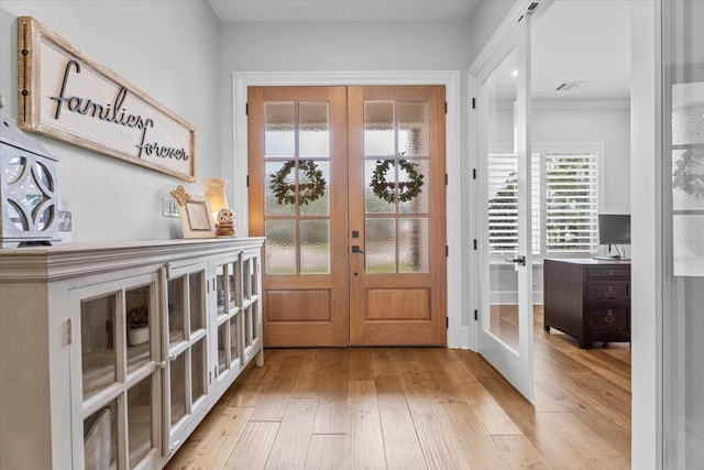 doorway featuring french doors, light hardwood / wood-style floors, and ornamental molding