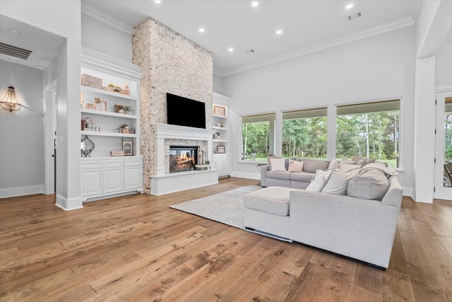 living room featuring a fireplace, light hardwood / wood-style floors, and ornamental molding