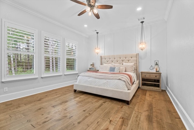 bedroom featuring ceiling fan, wood-type flooring, ornamental molding, and multiple windows