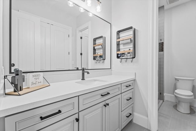 bathroom featuring tile patterned flooring, vanity, and toilet