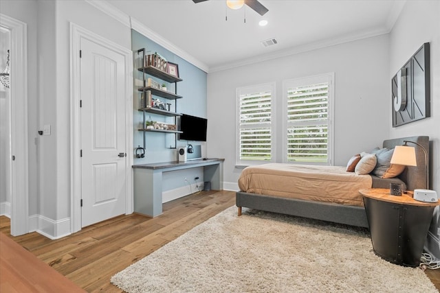 bedroom featuring ceiling fan, ornamental molding, and light wood-type flooring