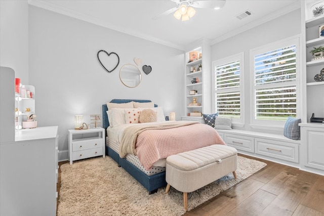 bedroom with hardwood / wood-style floors, ceiling fan, and crown molding