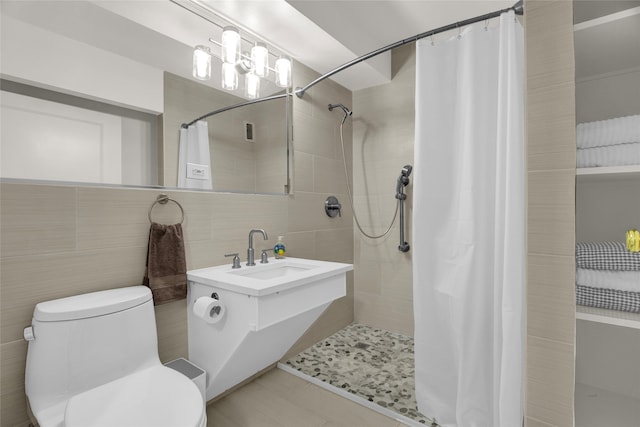 bathroom with walk in shower, tile patterned flooring, backsplash, toilet, and tile walls