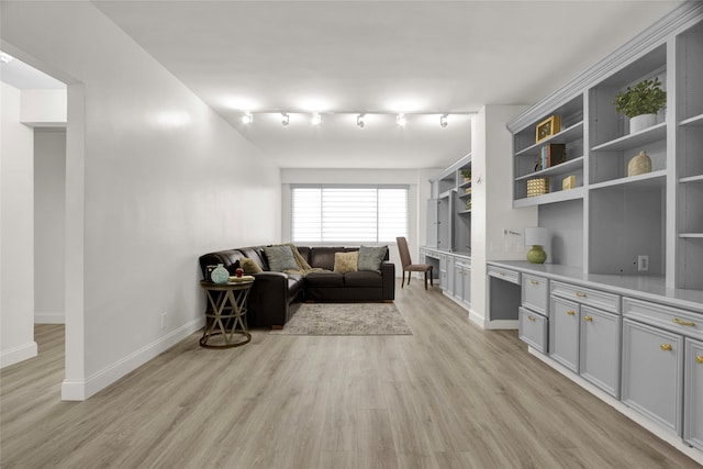 living room with light hardwood / wood-style flooring, built in desk, and track lighting