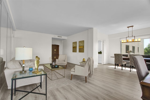 living room featuring a chandelier and light hardwood / wood-style flooring