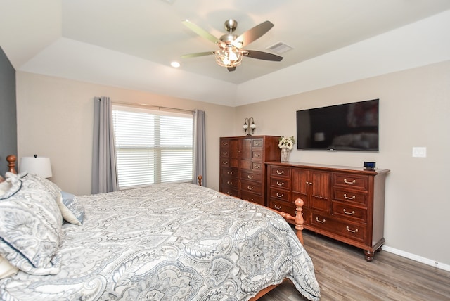 bedroom featuring a tray ceiling, ceiling fan, and hardwood / wood-style floors