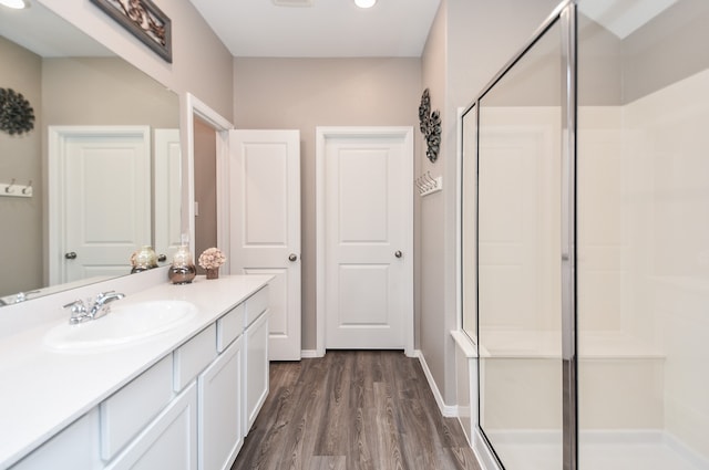 bathroom featuring hardwood / wood-style floors, vanity, and walk in shower