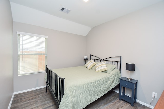 bedroom featuring dark wood-type flooring and vaulted ceiling