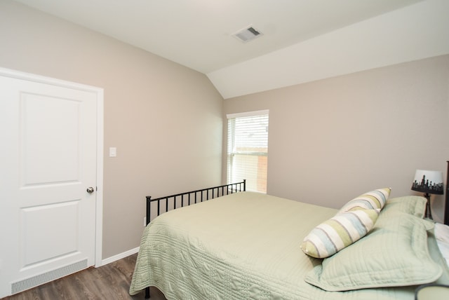 bedroom with dark hardwood / wood-style flooring and lofted ceiling