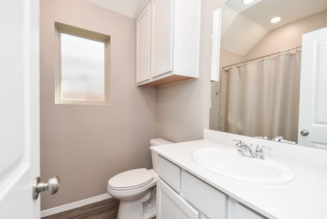 bathroom with vanity, wood-type flooring, lofted ceiling, and toilet