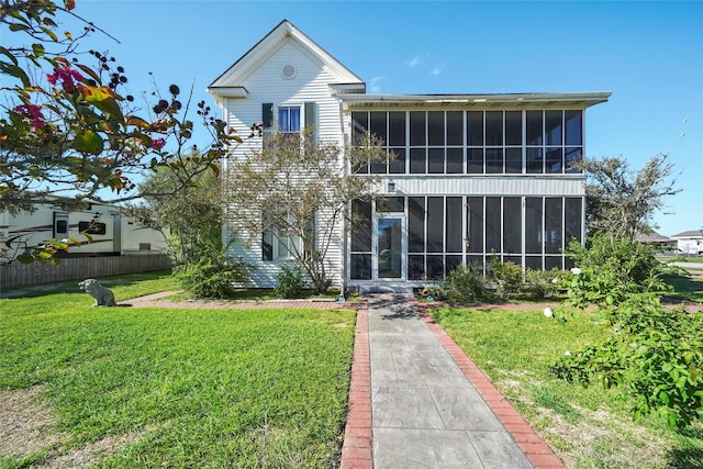 view of front facade with a sunroom and a front yard