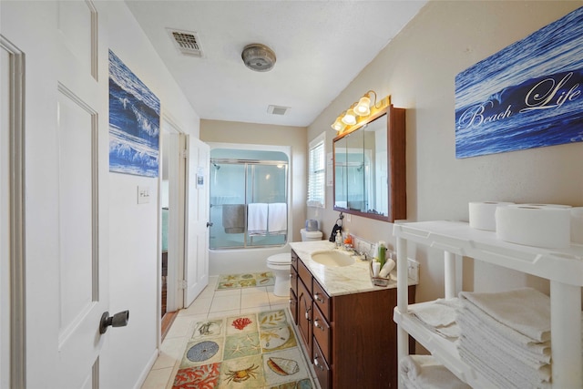 full bathroom with combined bath / shower with glass door, vanity, tile patterned flooring, and toilet