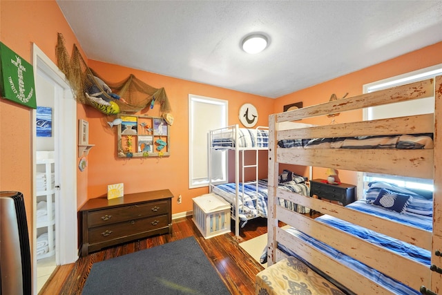 bedroom featuring dark hardwood / wood-style flooring and a textured ceiling