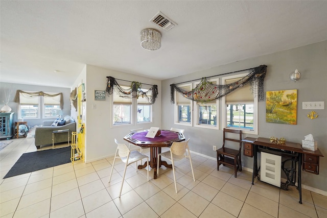 tiled dining space featuring a healthy amount of sunlight