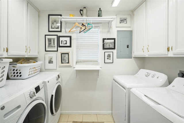 washroom featuring light tile patterned flooring, cabinets, separate washer and dryer, and electric panel