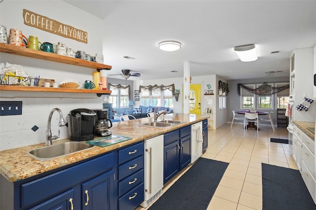 kitchen featuring ceiling fan, light tile patterned flooring, sink, and blue cabinetry