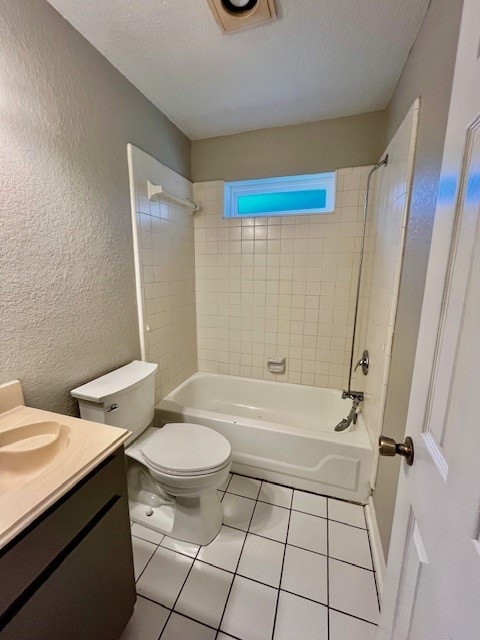 full bathroom with tile patterned floors, vanity, tiled shower / bath combo, and toilet