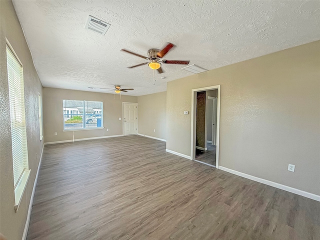 spare room with ceiling fan, dark hardwood / wood-style flooring, and a textured ceiling