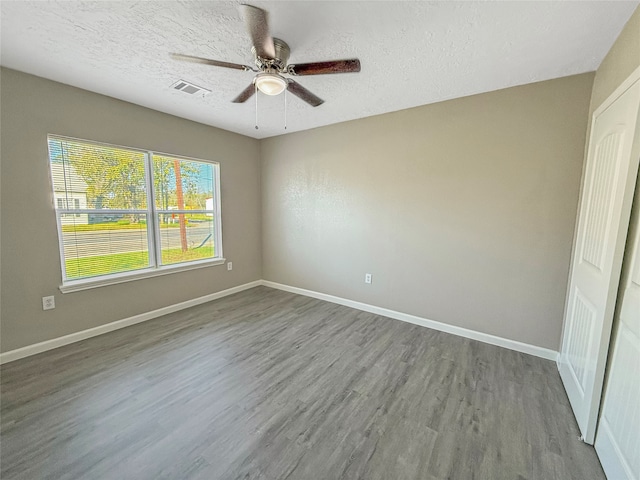 spare room with ceiling fan, a textured ceiling, and hardwood / wood-style flooring