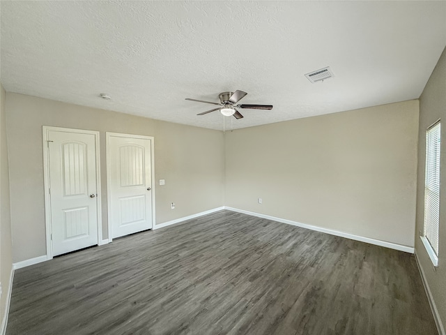 unfurnished room with a textured ceiling, dark hardwood / wood-style flooring, and ceiling fan